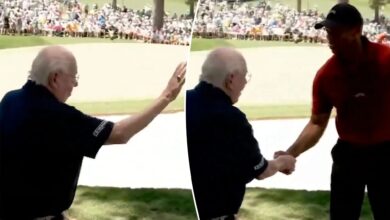 Tiger Woods shakes Verne Lundquist's hand on No. 16