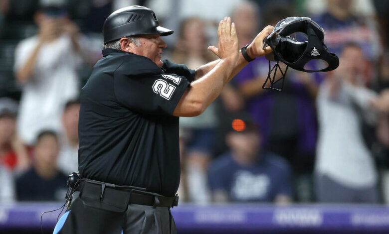 DENVER, COLORADO - JUNE 22: Home plate umpire Hunter Wendelstedt #21 calls a pitch time clock violation against Kyle Finnegan #67 of the Washington Nationals allowing a walk, walk-off win for the Colorado Rockies in the ninth inning at Coors Field on June 22, 2024 in Denver, Colorado. (Photo by Matthew Stockman/Getty Images)