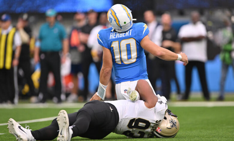 INGLEWOOD, CA - OCTOBER 27: New Orleans Saints defensive tackle Nathan Shepherd (93) rolls up on Los Angeles Chargers quarterback Justin Herbert (10) ankles during the game between the Saints and the Chargers on October 27, 2024, at SoFi Stadium in Inglewood, CA. (Photo by David Dennis/Icon Sportswire via Getty Images)