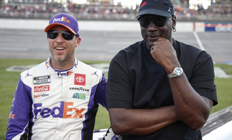 TALLADEGA, ALABAMA - OCTOBER 06: Co-owners of 23XI Racing, Denny Hamlin, driver of the #11 FedEx One Rate Toyota, and NBA Hall of Famer, Michael Jordan talk on the grid after the NASCAR Cup Series YellaWood 500 at Talladega Superspeedway on October 06, 2024 in Talladega, Alabama. (Photo by Chris Graythen/Getty Images)